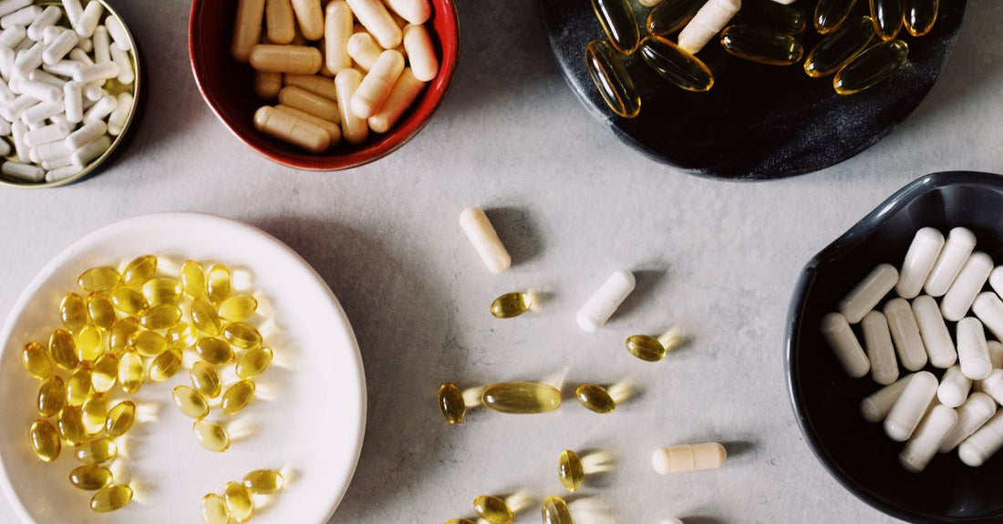 Frasco de multivitamínico para mujeres mayores de 40 con cápsulas derramadas sobre una superficie clara, representando el mejor multivitamínico para mujeres over 40.