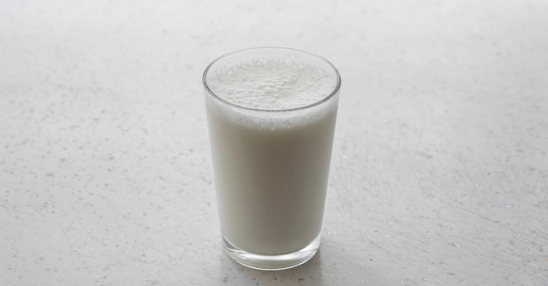 Vaso de leche y productos lácteos sobre una mesa