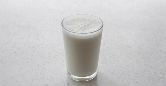 Vaso de leche y productos lácteos sobre una mesa