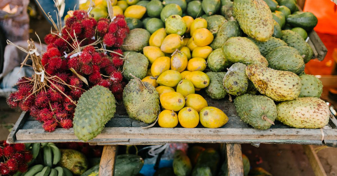 Fruta de soursop fresca sobre una mesa de madera rústica, mostrando su pulpa blanca y semillas negras.
