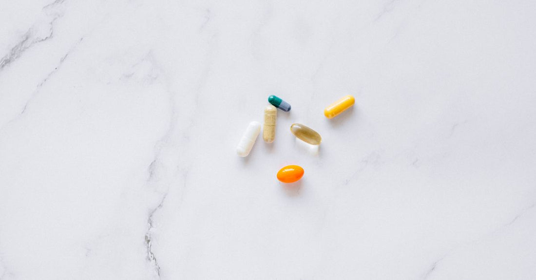 Cápsulas de biotina para el cabello y uñas sobre una superficie clara, representando suplementos de belleza.