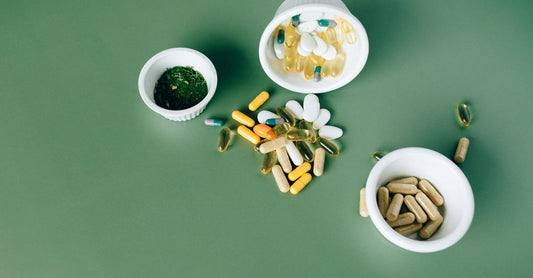 Bote de probióticos para la salud intestinal con cápsulas blancas y etiqueta verde sobre fondo claro.