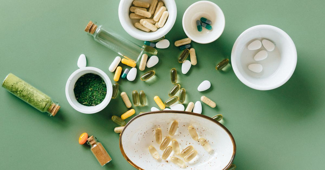 Botellas de suplementos de hierro para la anemia sobre una superficie clara con hojas verdes